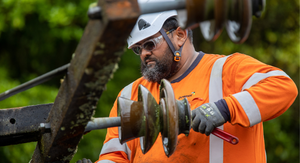 Downer crew member working on a cross-arm