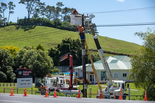 Field crew working up pole on overhead lines