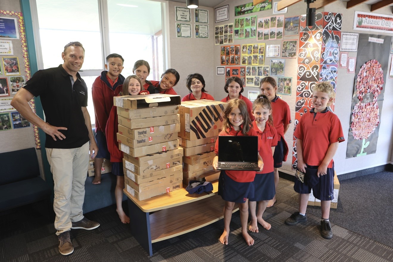 Powerco team member with laptops for school children.