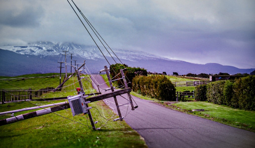 Power pole and power lines fallen into the road